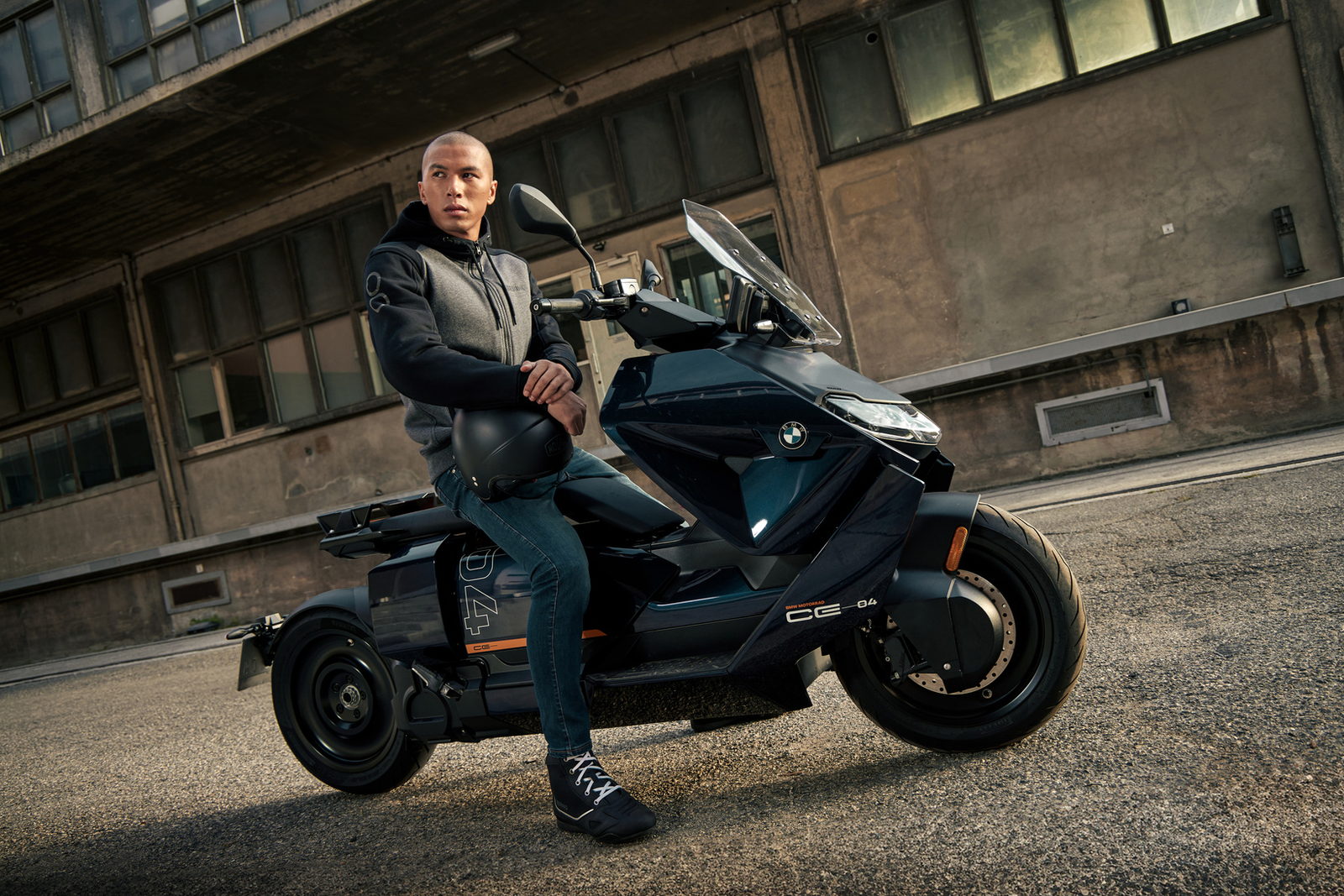 Scooter &eacute;lectrique BMW CE-04 devant un b&acirc;timent industriel, veste Bering.