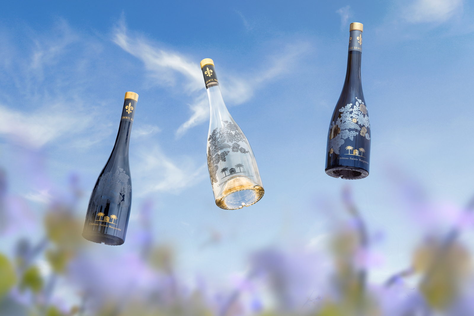 Visuel publicitaire Ch&acirc;teau Sainte Marguerite : trois bouteilles en l&eacute;vitation sur ciel bleu.