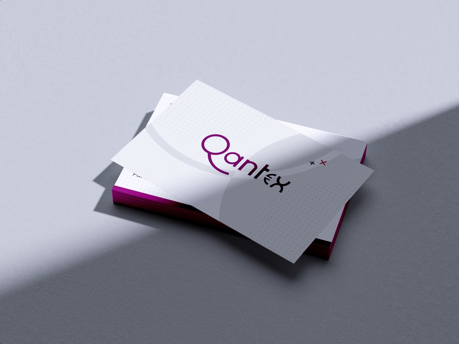 Pile de cartes de visite Qantex &agrave; tranche magenta, logo au &laquo;&nbsp;e&nbsp;&raquo; remplac&eacute; par une croix.