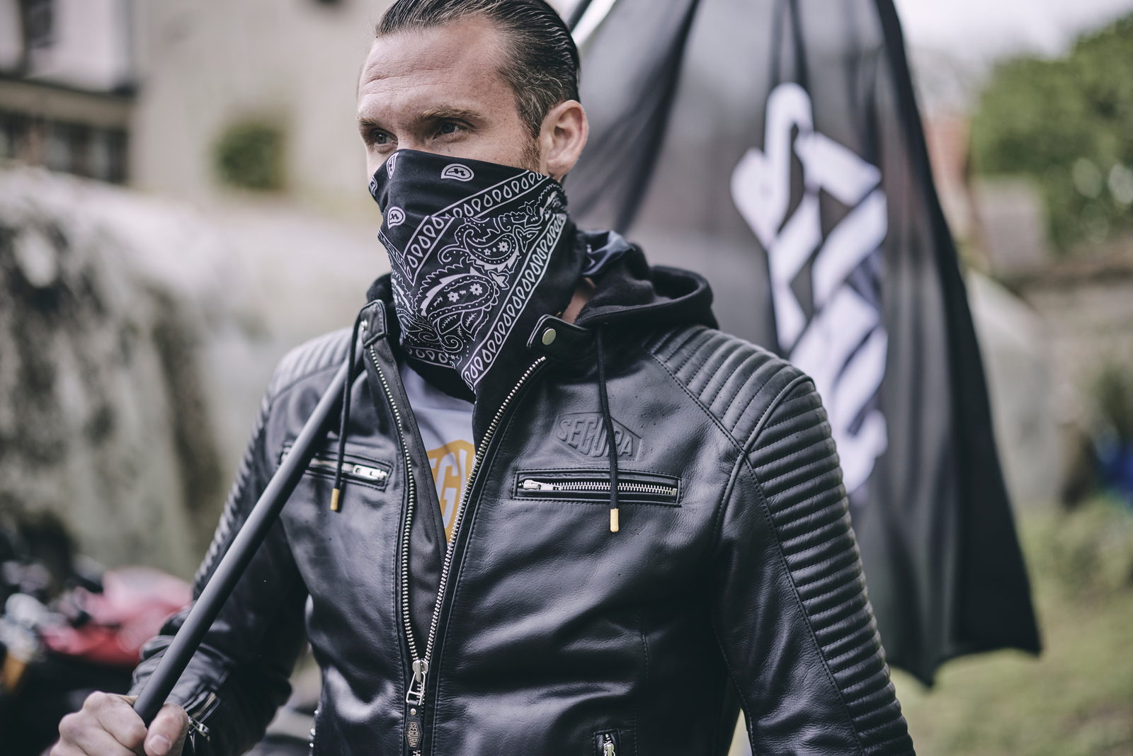 Portrait en veste de cuir Segura, bandana, drapeau en arri&egrave;re-plan.