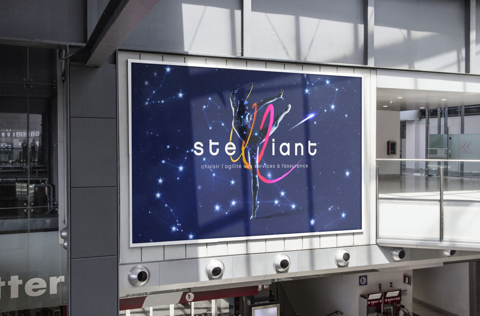 Le key visual Stelliant affich&eacute; sur un caisson lumineux dans un hall d'a&eacute;roport.
